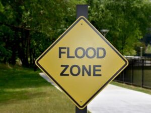 flood zone elevation certificate review - Pell City Land Surveying Flood zone warning sign representing elevation certificate review for property flood decisions