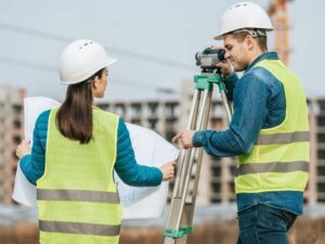 property development land surveying - Pell City Land Surveying Land surveyors reviewing property development plans with surveying equipment on site