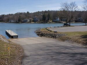 Shared boat ramp and dock in a reservoir community with access lane, parking area, and shoreline amenities.